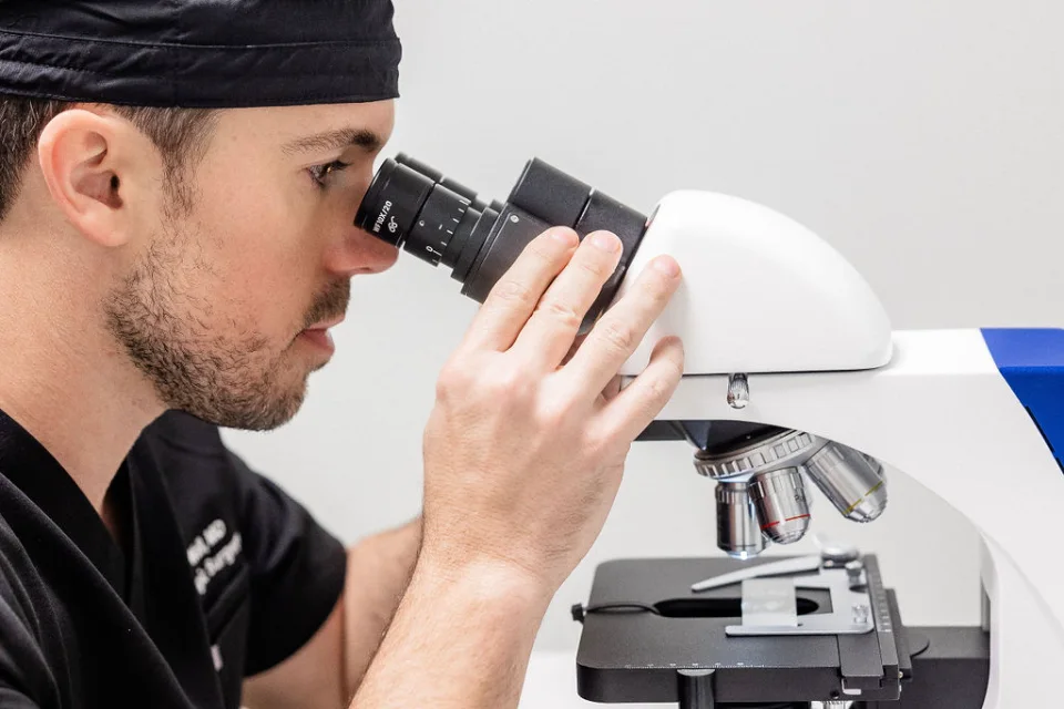 Dr. Wall examining Mohs margins under the microscope